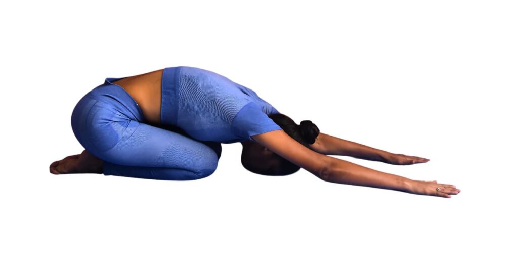 a female yoganta yoga teacher is in Child’s yoga pose (Bal Asana)