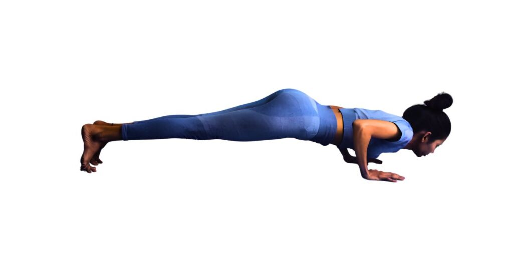 a female yoganta yoga teacher is in Four-Limbed Staff Pose (Chaturanga Dandasana)